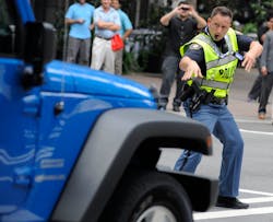 Clayton County (Ga.) Sheriff&apos;s Deputy John Strutko dances as he directs traffic Wednesday, Sept. 5, 2012, in Charlotte, N.C., during the second day of the Democratic National Convention.