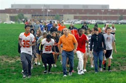 Normal Community High School students are led by a teacher to a nearby church as students were evacuated after shots were fired in a classroom at the high school Friday, Sept. 7, 2012, in Normal, Ill. Authorities say police have taken two people into custody. No one was injured.