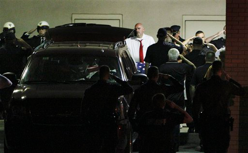 Police gather to salute the body of slain Plymouth Township canine officer Brad Fox, on Thursday Sept. 13, 2012, at Montgomery Hospital in Norristown Pa. The officer was shot and killed while responding to a hit-and-run in a Philadelphia suburb, authorities said.
