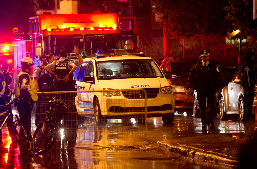 Police cordon off the rear outside an auditorium where a gunman shot and killed at least one person during the Parti Quebecois victory rally early Wednesday, Sept. 5, 2012 in Montreal. Police say a man fired a gun during a midnight victory rally for Quebec's new premier, killing one person and wounding another. The new premier, Pauline Marois of the separatist Parti Quebecois, was whisked off the stage and uninjured.