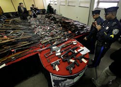 Camden police officers exaime guns displayed on tables at police headquarters in Camden, N.J. on Dec. 18. Camden police officers exaime guns displayed on tables at police headquarters in Camden, N.J. on Dec. 18.