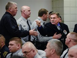 Deputies escort Al Lowry, the brother of murdered Highway Patrol Trooper, Ed Lowry, after he yelled an expletive at Cumberland County Superior Court Judge Gregory A. Weeks.