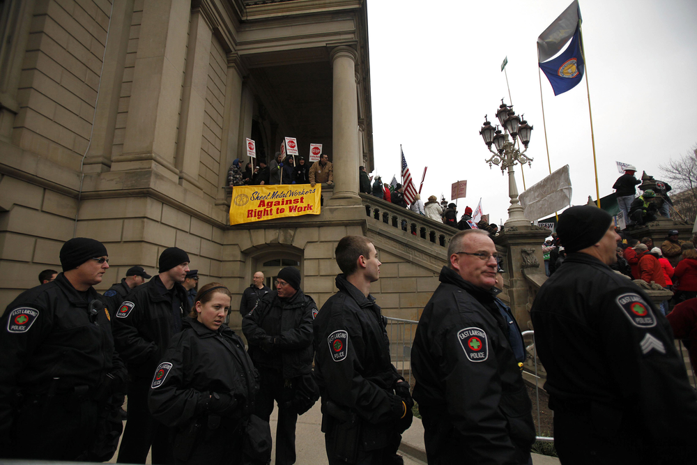 Police from Lansing are on standby as the protest against right-to-work legislation continues outside the Michigan State Capitol on Dec. 11.