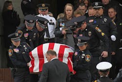 The casket of Cold Spring-Richmond Officer Thomas Decker is carried from St. John&apos;s Abbey and University Church at St. John&apos;s University in Collegeville, Minn. on Dec. 5.