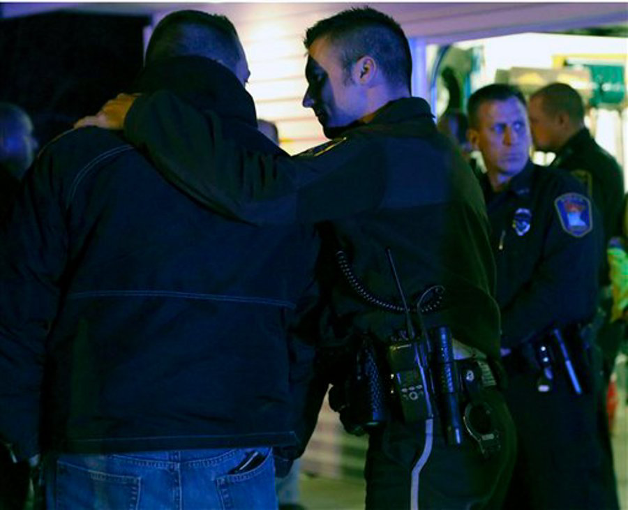 Law enforcement officers console each other as they looked in on the hearse carrying the body of fallen Officer Tom Decker at Wenners Funeral home in Cold Spring, Minn. on Nov. 30.