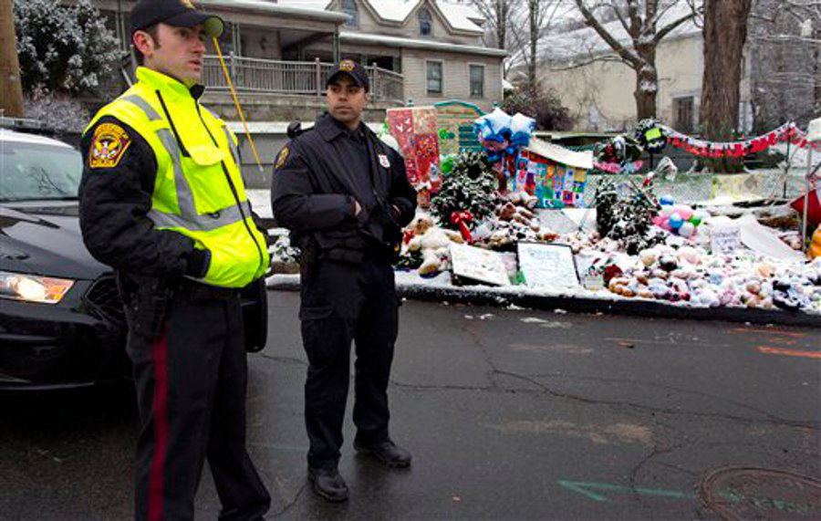 Two officers from departments near Newtown, Conn. stand near a memorial as they relieve local officers for the Christmas holiday.