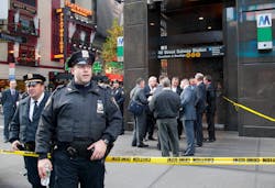 Uniformed and plainclothes police officers stand outside a New York subway station after a man was killed after falling into the path of a train on Dec. 3.