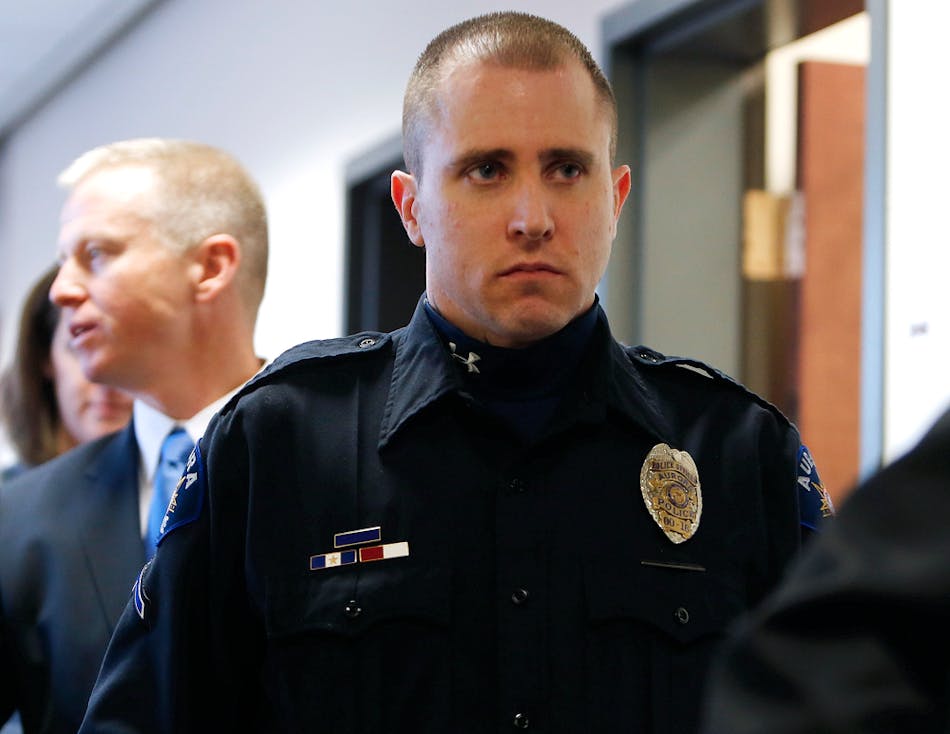 Aurora Police Officer Justin Grizzle leaves court after testifying at a preliminary hearing for James Holmes at the courthouse in Centennial, Colo. on Jan. 7.