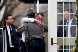 Police officers comfort one another outside a funeral service for 6-year-old Noah Pozner on Dec. 17, 2012, just days after a school shooting in Newtown, Conn. Police officers comfort one another outside a funeral service for 6-year-old Noah Pozner on Dec. 17, 2012, just days after a school shooting in Newtown, Conn.