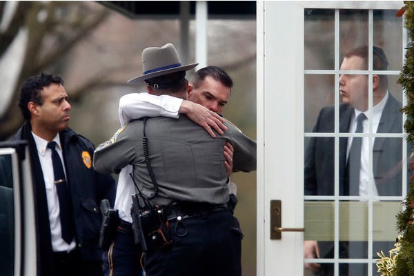Police officers comfort one another outside a funeral service for 6-year-old Noah Pozner on Dec. 17, 2012, just days after a school shooting in Newtown, Conn.