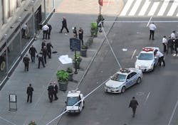 Police surround a sheet covered body on a Fifth Avenue sidewalk as they investigate a multiple shooting outside the Empire State Building in New York on Aug. 24, 2012.