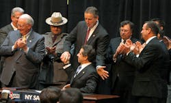 New York Gov. Andrew Cuomo, seated at center, gets a congratulatory hand shake from Lt. Gov. Robert Duffy after signing the NY Safe Act on Jan. 16. New York Gov. Andrew Cuomo, seated at center, gets a congratulatory hand shake from Lt. Gov. Robert Duffy after signing the NY Safe Act on Jan. 16.