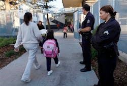 LAPD Sgt. Frank Preciado, along with Officer Wendy Reyes, keeps watch over children arriving at the Main Street Elementary School after winter break on Jan. 7. LAPD Sgt. Frank Preciado, along with Officer Wendy Reyes, keeps watch over children arriving at the Main Street Elementary School after winter break on Jan. 7.