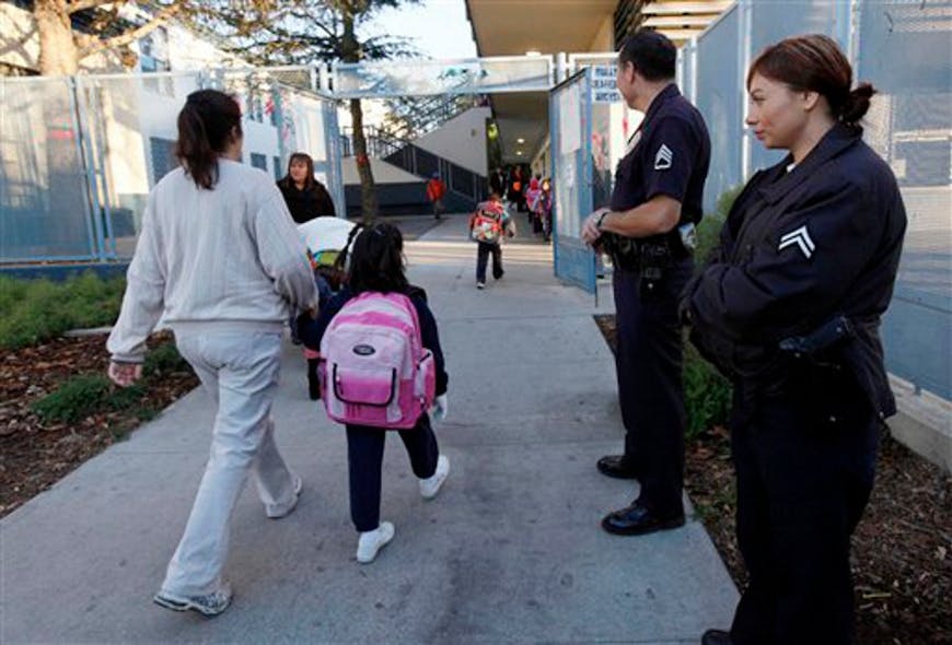 LAPD Sgt. Frank Preciado, along with Officer Wendy Reyes, keeps watch over children arriving at the Main Street Elementary School after winter break on Jan. 7.