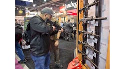 Stuart Konicar looks down the sight of a Remington Adaptive Combat Rifle on display at the Remington Defense exhibit during the SHOT Show on Jan. 15 in Las Vegas.