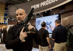 Sig Sauer representative Adam Painchaud explains one of the company's newest products, the MPX 9mm pistol caliber submachine gun at the 35th annual SHOT Show on Jan. 15 in Las Vegas. Sig Sauer representative Adam Painchaud explains one of the company's newest products, the MPX 9mm pistol caliber submachine gun at the 35th annual SHOT Show on Jan. 15 in Las Vegas.