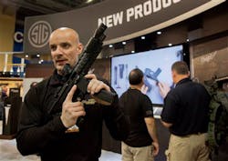 Sig Sauer representative Adam Painchaud explains one of the company&apos;s newest products, the MPX 9mm pistol caliber submachine gun at the 35th annual SHOT Show on Jan. 15 in Las Vegas.