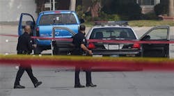 LAPD Officers pass by at a truck in Torrance, Calif. on Feb. 7 that mistakenly shot at after authorities believed it was the same one driven by Christopher Dorner.