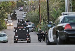 An armored vehicle arrives in support of police and sheriff&apos;s officers outside a home in Encinitas, Calif. on Feb. 20.