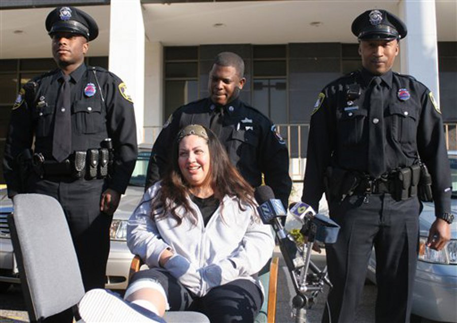 April Genao talks about how Petersburg Officer Wendell James, right, caught her and her family after an apartment fire.