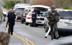 Law enforcement officials respond to a report of a man walking around the area shooting at homes in a neighborhood in Tacoma, Wash. on March 26. Law enforcement officials respond to a report of a man walking around the area shooting at homes in a neighborhood in Tacoma, Wash. on March 26.