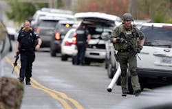 Law enforcement officials respond to a report of a man walking around the area shooting at homes in a neighborhood in Tacoma, Wash. on March 26.