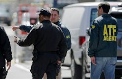 A Boston police officer, front left, talks with two ATF agents at the scene of the Boston Marathon explosions