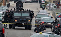Police in tactical gear arrive on an armored police vehicle as they surround an apartment building while looking for a suspect in the Boston Marathon bombings in Watertown, Mass. on April 19. Police in tactical gear arrive on an armored police vehicle as they surround an apartment building while looking for a suspect in the Boston Marathon bombings in Watertown, Mass. on April 19.