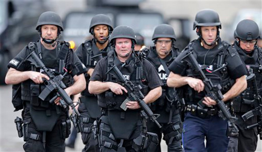 A SWAT team marches through a neighborhood while searching for a suspect in the Boston Marathon bombings in Watertown, Mass. on April 19.