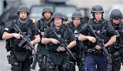 A SWAT team marches through a neighborhood while searching for a suspect in the Boston Marathon bombings in Watertown, Mass. on April 19. A SWAT team marches through a neighborhood while searching for a suspect in the Boston Marathon bombings in Watertown, Mass. on April 19.