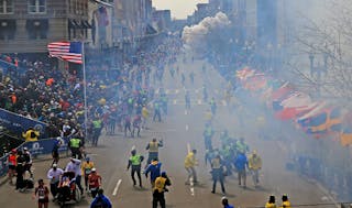 People react as an explosion goes off near the finish line of the 2013 Boston Marathon on April 15.