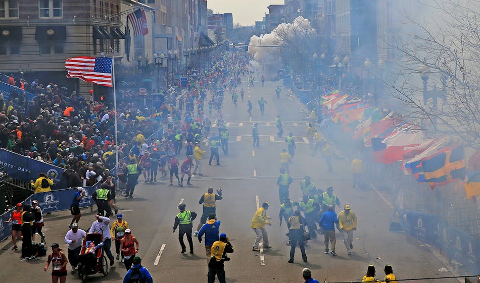 People react as an explosion goes off near the finish line of the 2013 Boston Marathon on April 15.
