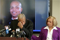 Carolyn Wortham comforts her husband Thomas Wortham III, as he speaks of their late son, Chicago Police Officer Thomas Wortham IV, during a news conference on April 24.