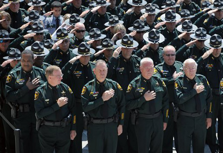 Members of the Polk County Sheriff's Office including Sheriff Grady Judd, front left, salute during a funeral service for Deputy Joseph Robbins at the First Baptist Church at the Mall in Lakeland, Fla. on April 30.