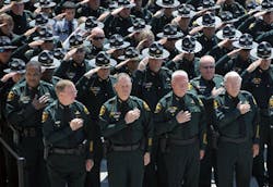 Members of the Polk County Sheriff&apos;s Office including Sheriff Grady Judd, front left, salute during a funeral service for Deputy Joseph Robbins at the First Baptist Church at the Mall in Lakeland, Fla. on April 30.
