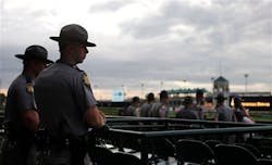 Kentucky State Police watch the race track during morning workouts at Churchill Downs on May 3 in Louisville, Ky.