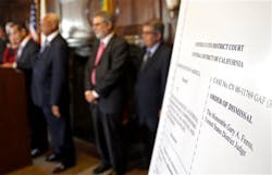 An poster with an enlarged view of the dismissal of the 2001 Los Angeles Police Department consent decree is seen as the mayor, police chief, and police commission board members appear at police headquarters on May 16.