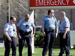 Minneapolis police officers stand outside the Hennepin County Medical Center following the shooting of two fellow officers after they pursued a suspect on May 10.