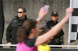 Pittsburgh Police stand guard as runners head to the finish of the Pittsburgh Marathon on May 5.