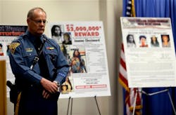 Col. Rick Fuentes, superintendent of the New Jersey State Police, stands next to posters during a news conference giving updates on the search of Joanne Chesimard on May 2, 2013.