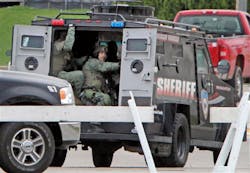 The Dane County Sheriff&apos;s Office Tactical Response Team drives away from a makeshift command center at Fire Station 2 in Fitchburg, Wis. on May 2.