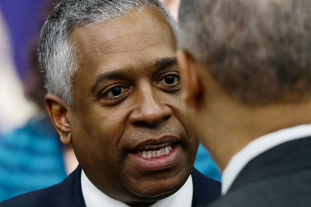 Acting ATF Director B. Todd Jones talks to Attorney General Eric Holder in the South Court Auditorium at the White House in Washington, D.C.