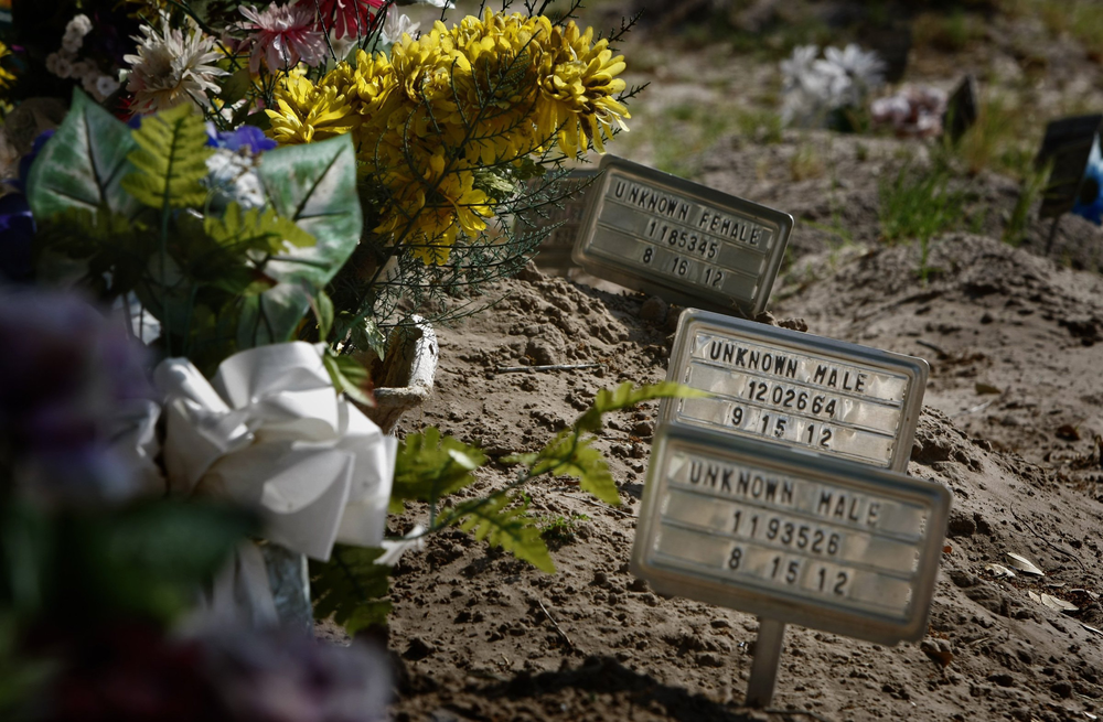Small signs and artificial flowers mark the graves of unidentified immigrants buried in Sacred Heart Cemetery in Falfurrias, Texas on April 8.
