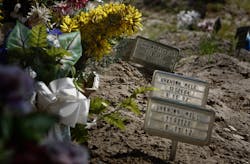 Small signs and artificial flowers mark the graves of unidentified immigrants buried in Sacred Heart Cemetery in Falfurrias, Texas on April 8.