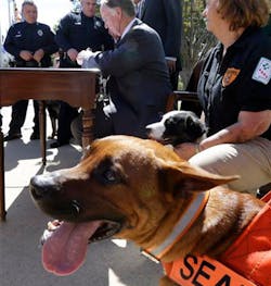 Alabama Gov. Robert Bentley applies his signature to a bill that will provide penalties for injuring or interfering with police or rescue dogs outside the Capitol in Montgomery, Ala. on June 5.