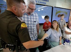 Lynette Hales shakes hands with Utah Trooper Cameron Fawson while Jim Gerber, center, watches following a news conference at Intermountain Medical Center on June 3 in Murray, Utah.