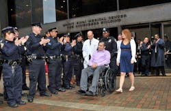 NYPD Officer Eder Loor leaves the hospital with his wife, Dina, by his side on May 2, 2012. Dina joined the police department this week after graduating from the academy.