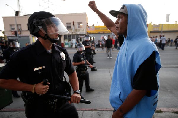 A protester confronts a Los Angles police officer during a demonstration in reaction to the acquittal of neighborhood watch volunteer George Zimmerman on July 15.
