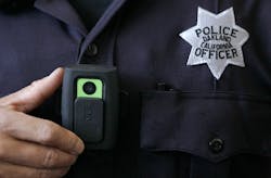 Officer Huy Nguyen shows a video camera worn by some officers in Oakland, Calif.