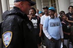 A police officer walks past supporters of the NYPD Oversight override vote on Aug. 22. A police officer walks past supporters of the NYPD Oversight override vote on Aug. 22.